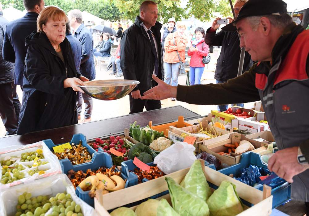 Angela Merkel achète des fruits et légumes au marché de Barth.© Stefan Sauer \/ AFP